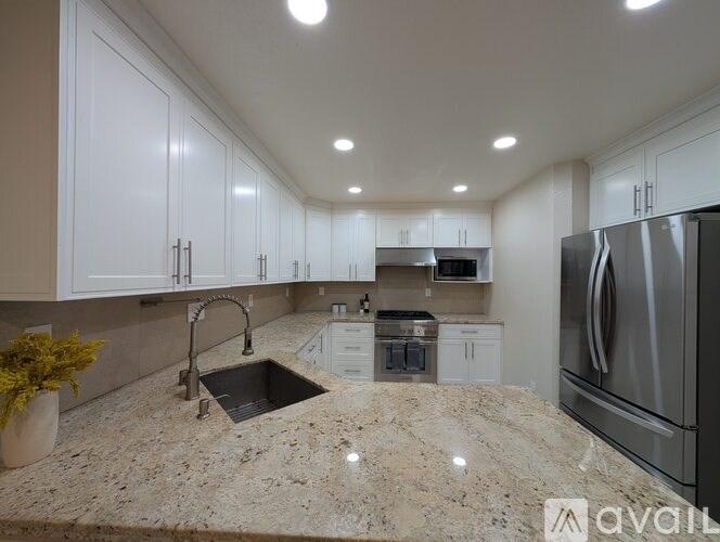 A kitchen with granite countertops and stainless steel appliances.