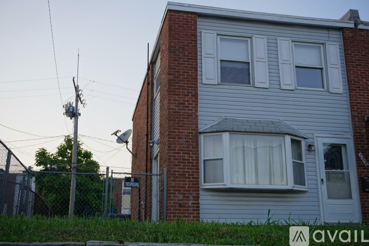 A house with a grey siding and a white window.
