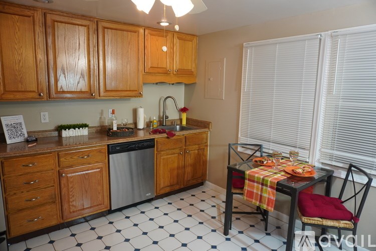A kitchen with wooden cabinets and a black and white checkered floor.
