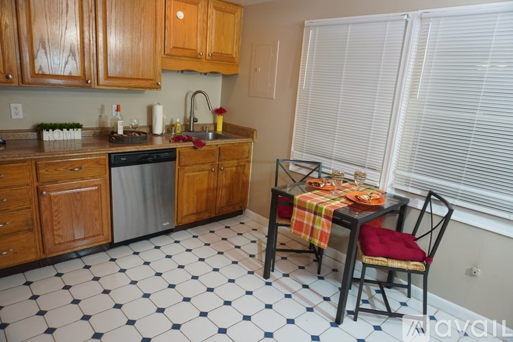A kitchen with a table set for two with a red chair.