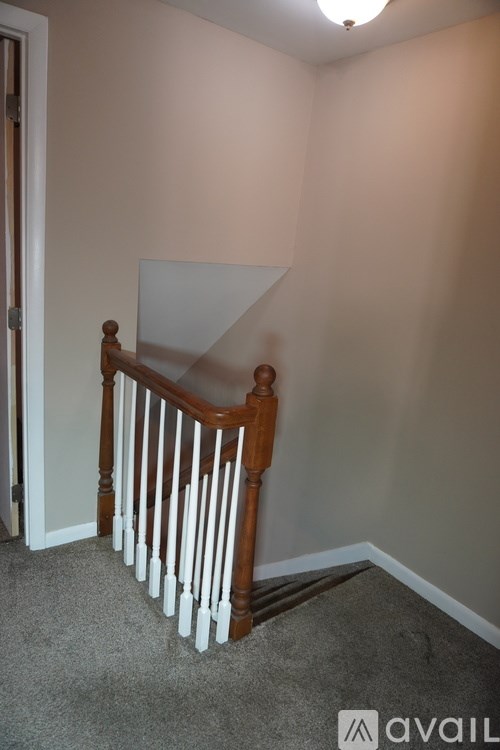A person is holding a white square in a room with a carpeted floor.