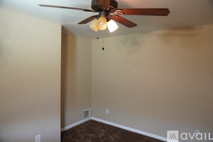 A room with a ceiling fan and light fixture.