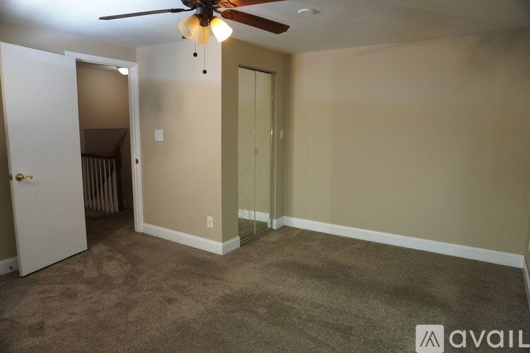 A room with a ceiling fan and carpeted floor.