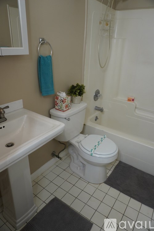 A bathroom with a toilet, sink, and bathtub.