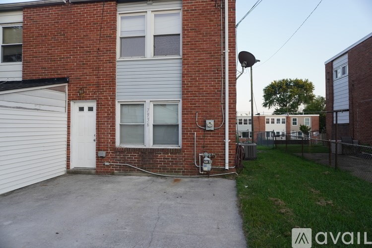 A brick house with a white garage door and a satellite dish on the roof.