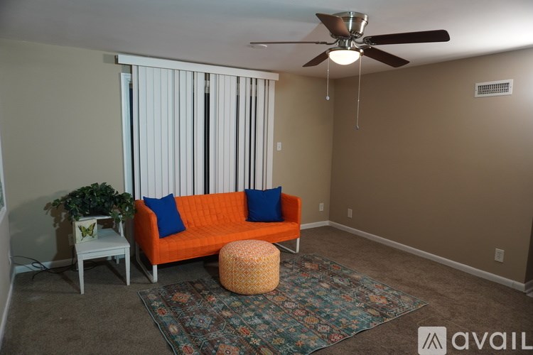 A living room with a sofa, a small table, and a ceiling fan.
