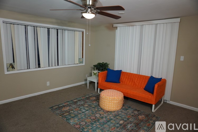 A living room with a ceiling fan, a sofa, and a small table.