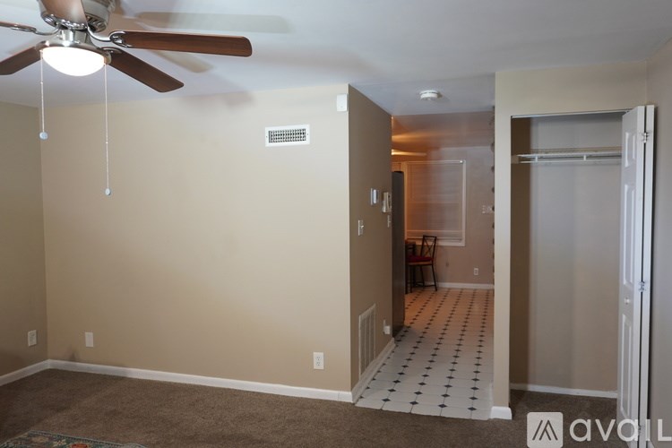 A room with a ceiling fan and a carpeted floor.