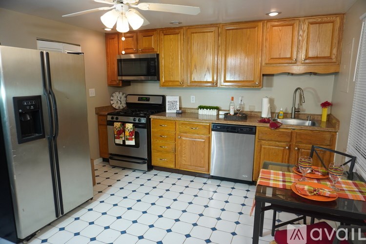 A kitchen with wooden cabinets and a black and white checkered floor.