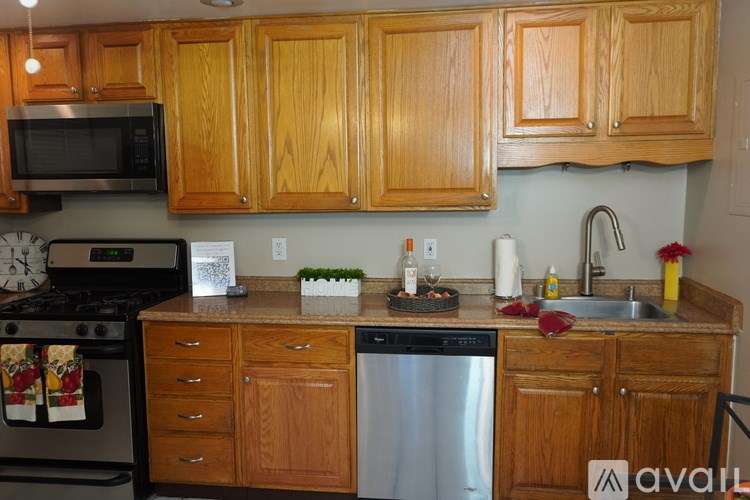 A kitchen with wooden cabinets and a stainless steel dishwasher.