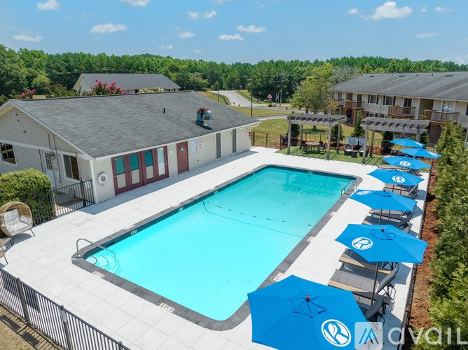 A large swimming pool surrounded by blue umbrellas and lounge chairs.
