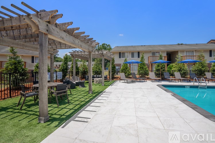 A sunny day at the poolside with a wooden pergola providing shade.