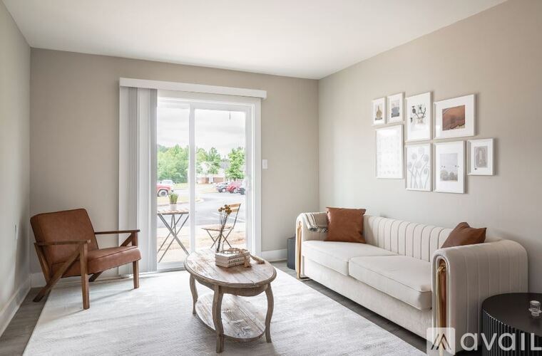 A living room with a couch, chair, and pictures on the wall.