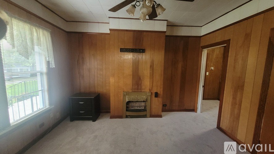 A room with wooden walls and a fireplace.