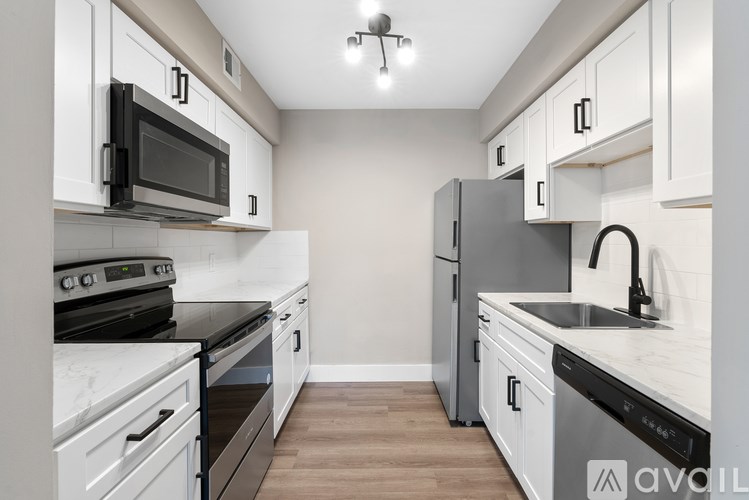 A kitchen with white cabinets and black appliances.