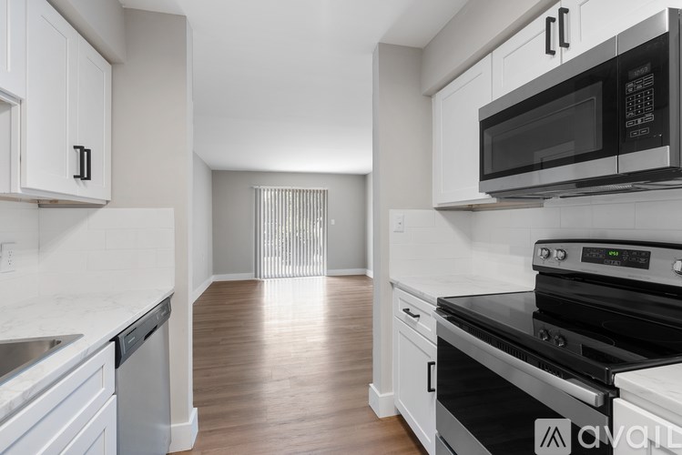 A kitchen with white cabinets and black appliances.