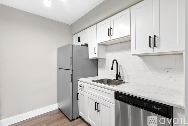 A kitchen with white cabinets and a stainless steel dishwasher.