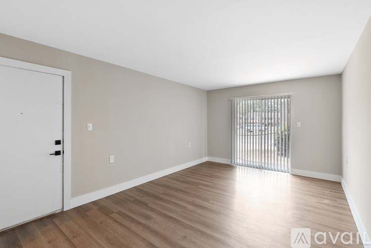 A room with wooden flooring and a white door.