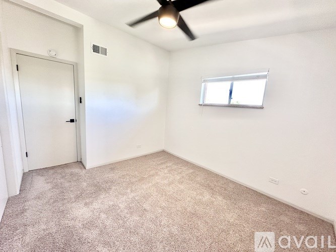 A room with a ceiling fan and a window with blinds.