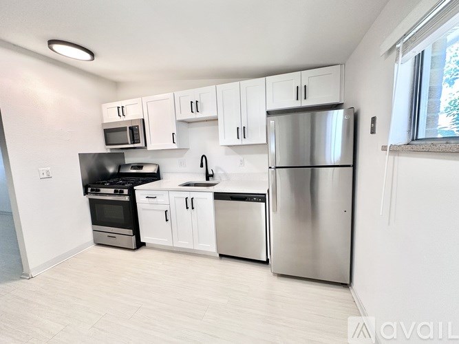 A kitchen with white cabinets and stainless steel appliances.