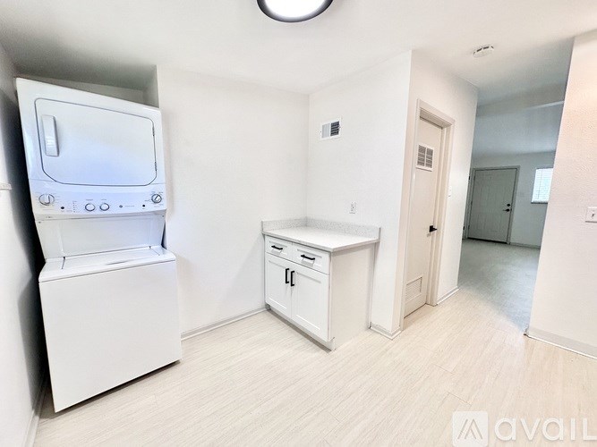 A kitchen area with a white fridge, dishwasher, and a white cabinet.