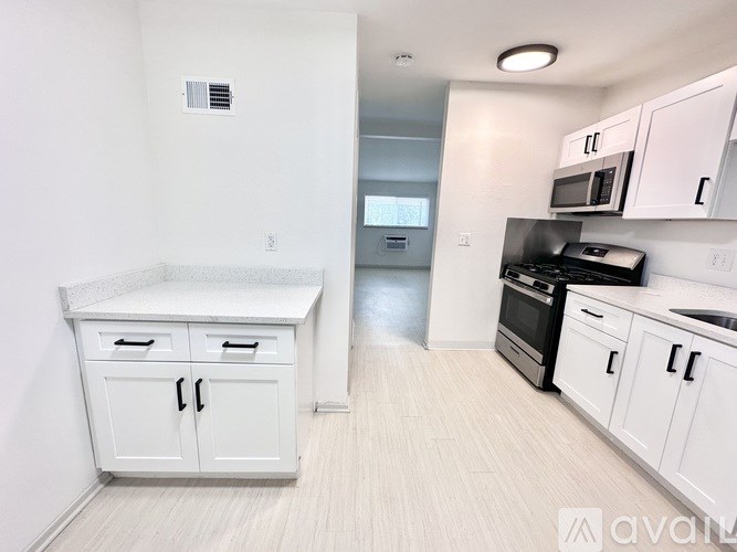 A kitchen with white cabinets and a countertop.
