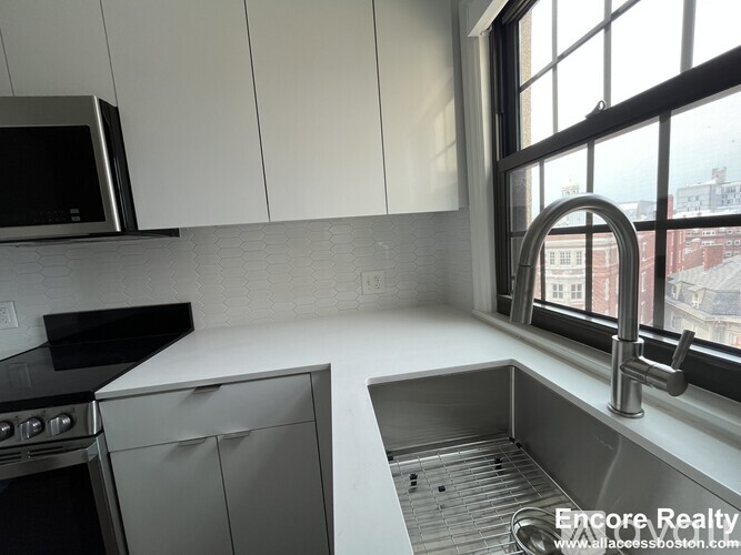 A kitchen with stainless steel appliances and white cabinets.