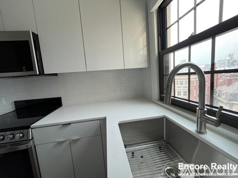 A kitchen with stainless steel appliances and white cabinets.