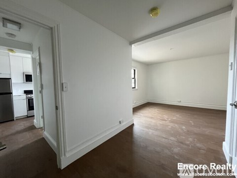 A room with white walls and wooden flooring is shown.