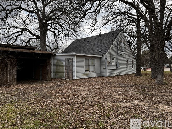 A house with a garage is surrounded by trees.