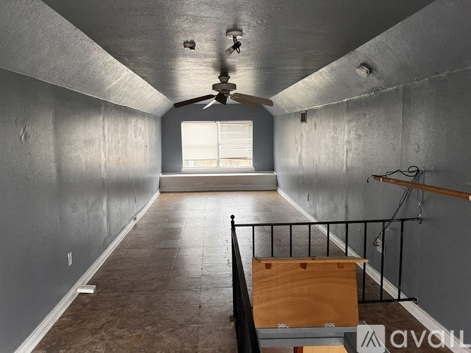 A room with a ceiling fan and a window.