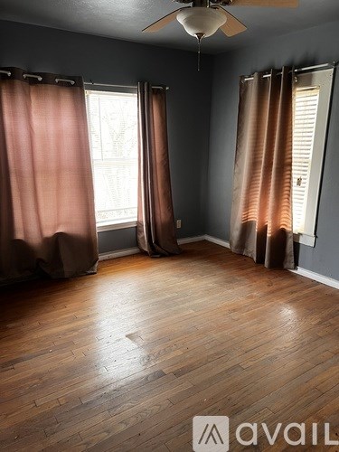 A room with wooden floors and a ceiling fan.
