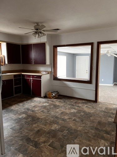 A kitchen with a fan on the ceiling and a tiled floor.