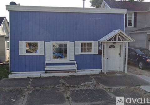 A blue house with a white door and windows.