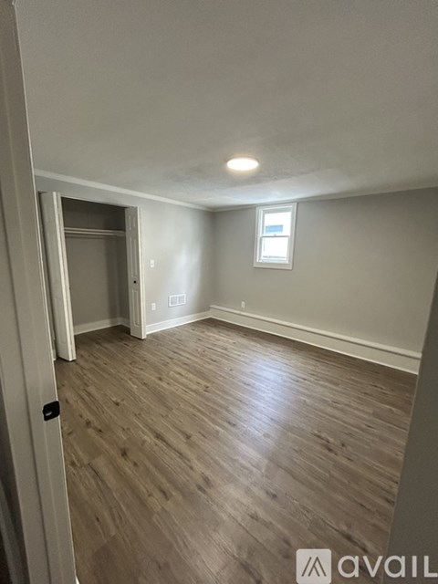 A room with wooden flooring and a window.