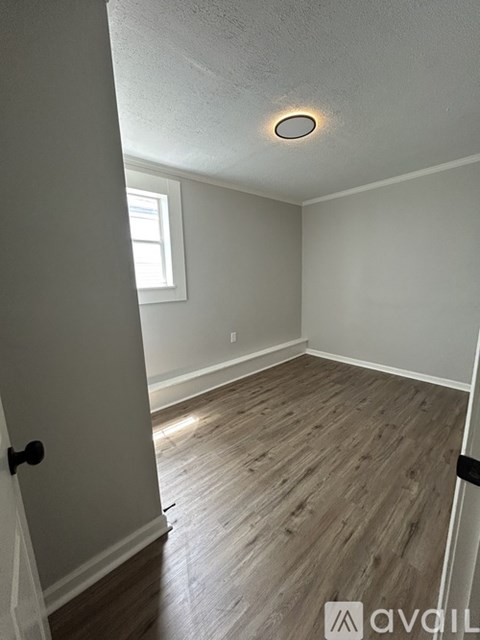 A room with wooden flooring and a window.