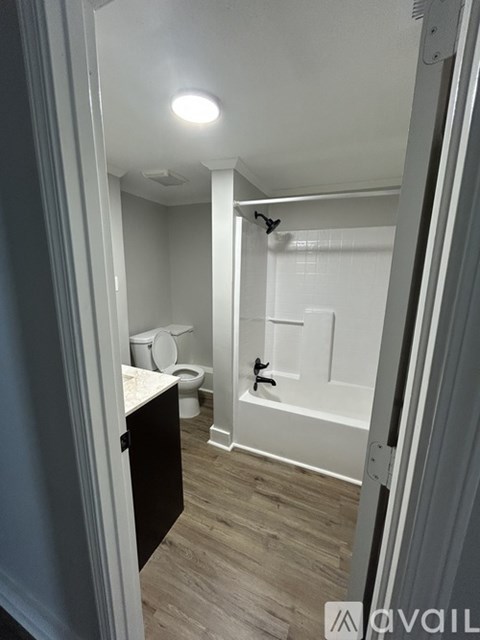 A bathroom with a toilet, sink, and bathtub.