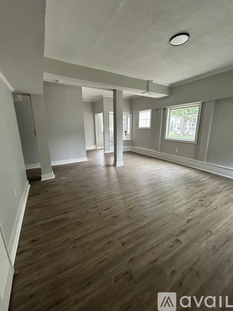 A room with wooden flooring and white walls.