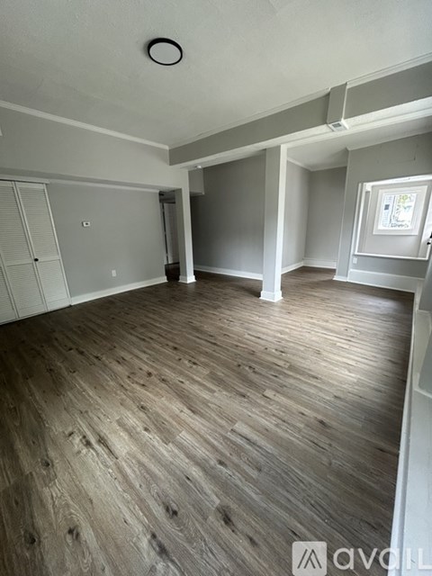 A room with wooden flooring and white walls.