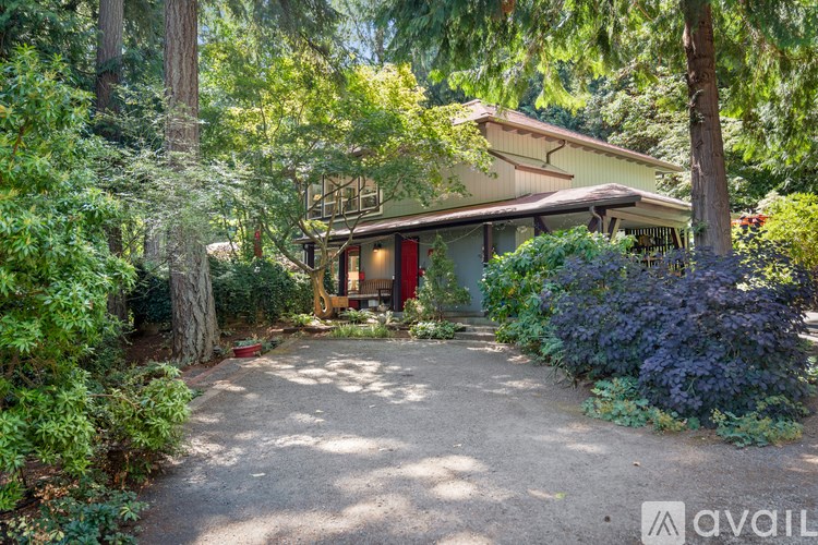 A house with a gravel driveway surrounded by greenery.