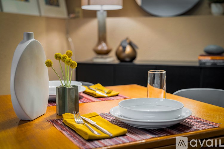 A table set with a white plate, yellow napkin, and silverware.