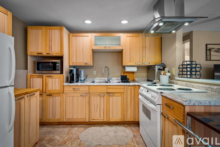 A kitchen with wooden cabinets and a white refrigerator.