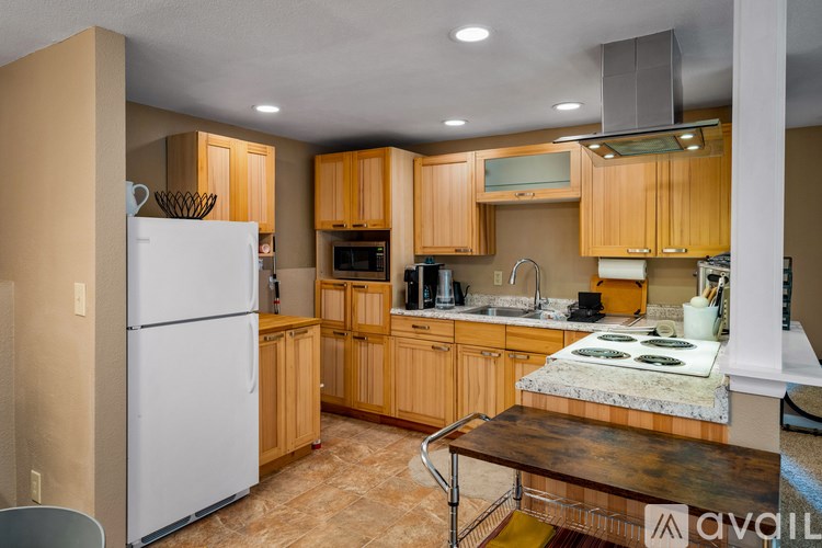 A kitchen with wooden cabinets and a white refrigerator.