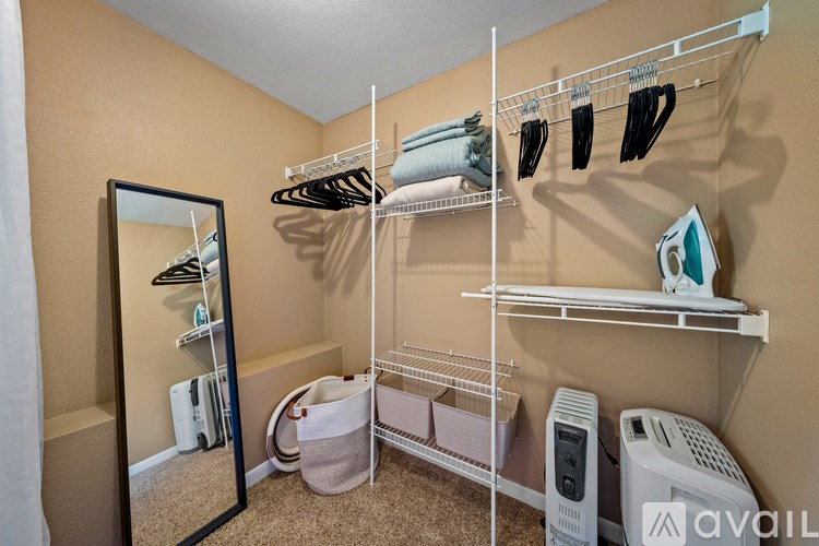 A small closet with a mirror and a shelf.