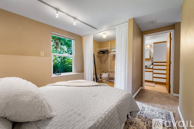 A bedroom with a large bed and a window.