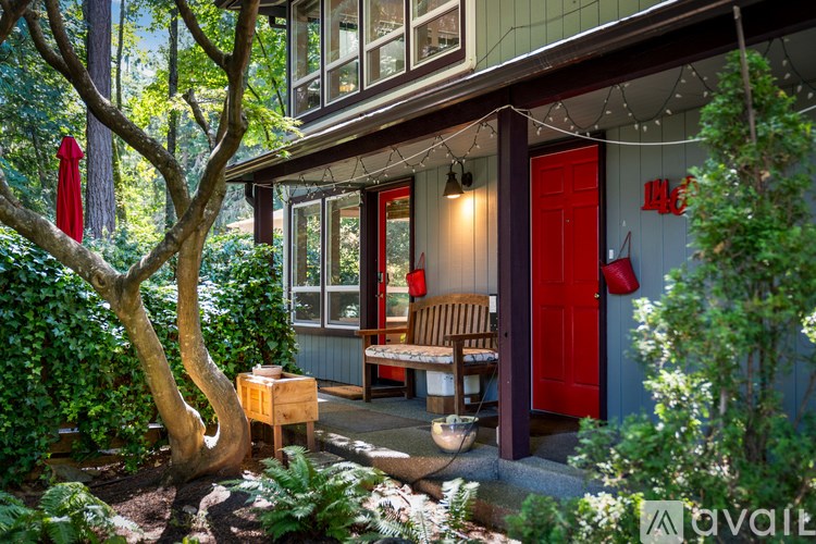 A tree in a garden in front of a house.
