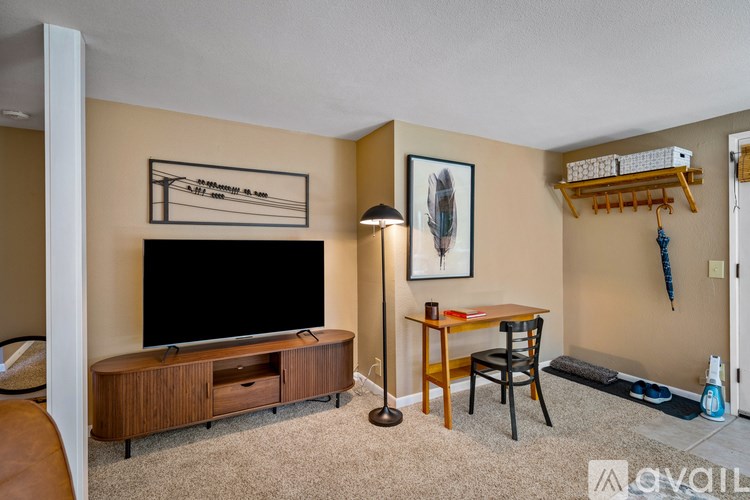 A living room with a television, chair, and table.