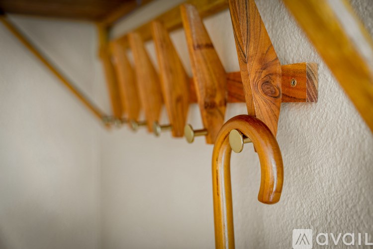 A row of wooden clothes pegs are attached to a wooden rod.