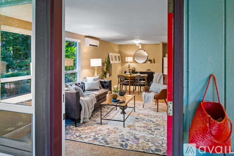 A living room with a couch, chairs, and a rug.