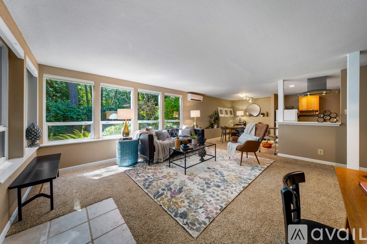 A living room with a rug, chairs, and a table.